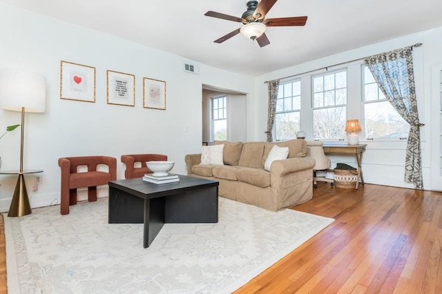 living room with wood-type flooring and ceiling fan