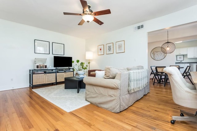 living room featuring ceiling fan and light hardwood / wood-style flooring