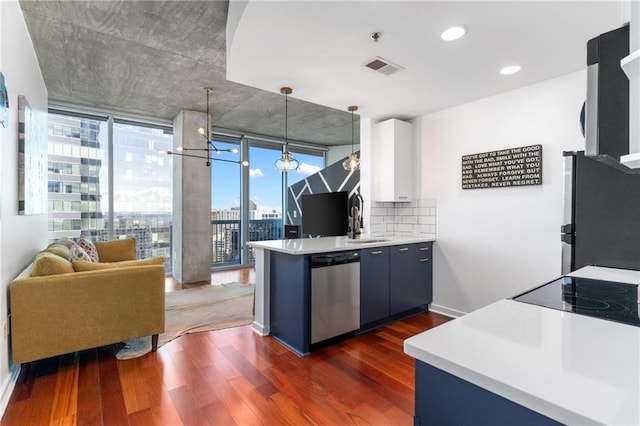 kitchen featuring floor to ceiling windows, hanging light fixtures, dark hardwood / wood-style floors, stainless steel appliances, and decorative backsplash