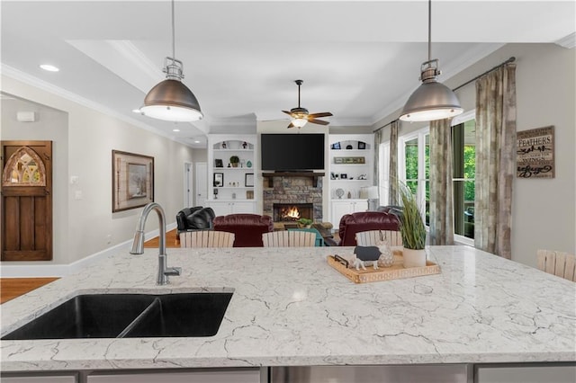 989 Pink Williams Rd, Dahlonega, GA 30533 - kitchen featuring a sink, a ceiling fan, ornamental molding, hanging light fixtures, and a stone fireplace