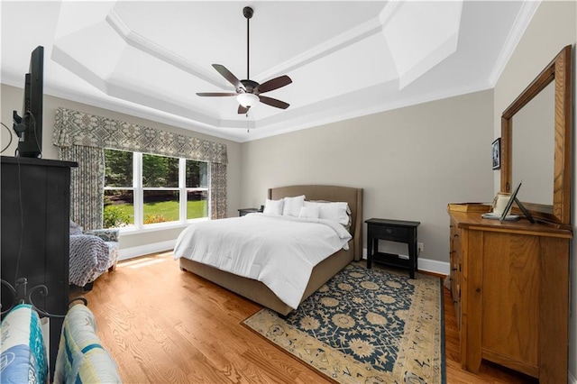 989 Pink Williams Rd, Dahlonega, GA 30533 - bedroom featuring a raised ceiling, light wood-type flooring, ornamental molding, a ceiling fan, and baseboards
