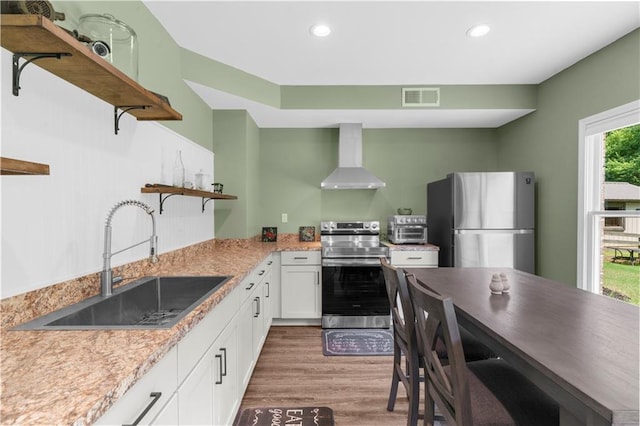 989 Pink Williams Rd, Dahlonega, GA 30533 - kitchen featuring open shelves, appliances with stainless steel finishes, wall chimney range hood, a sink, and white cabinetry