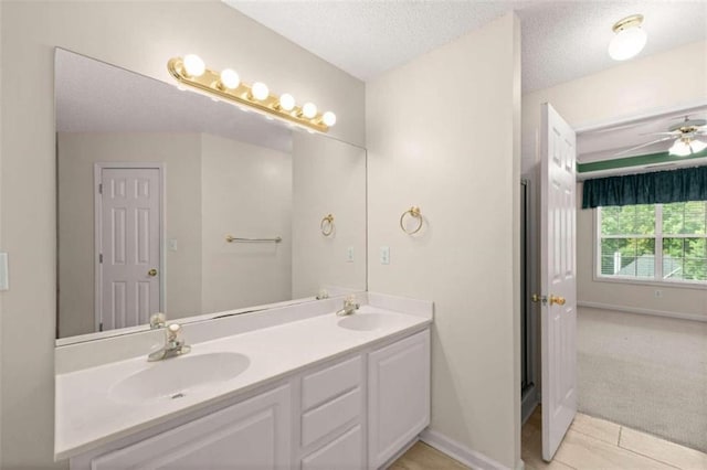 bathroom featuring ceiling fan, vanity, and a textured ceiling