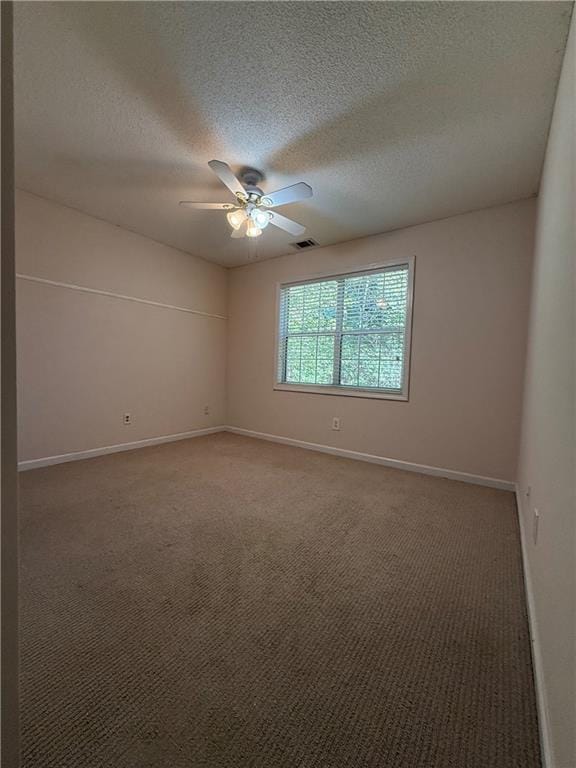 empty room featuring a textured ceiling, ceiling fan, and carpet floors