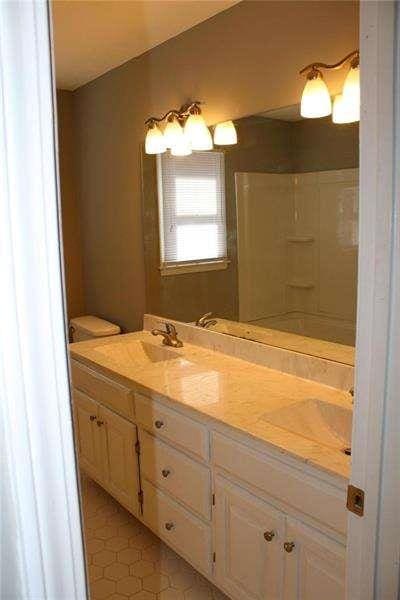 2031 Lakewood Cir, Grayson, GA 30017 - bathroom featuring double vanity and a shower