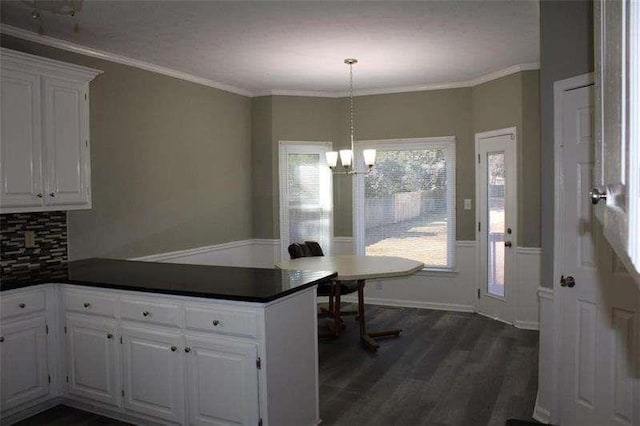 2031 Lakewood Cir, Grayson, GA 30017 - dining area featuring a chandelier, dark wood finished floors, crown molding, and a wainscoted wall