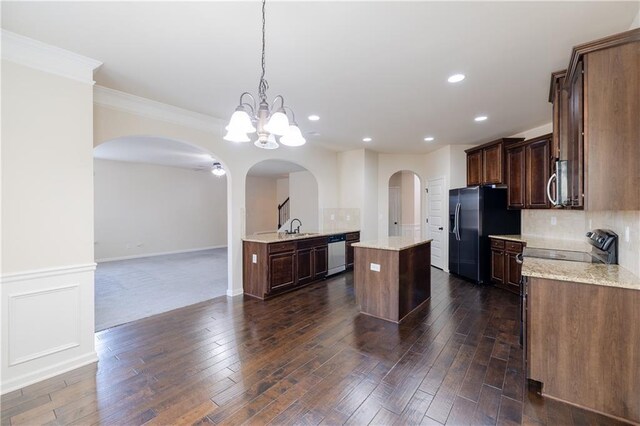 unfurnished living room with a fireplace, sink, ceiling fan, and dark colored carpet