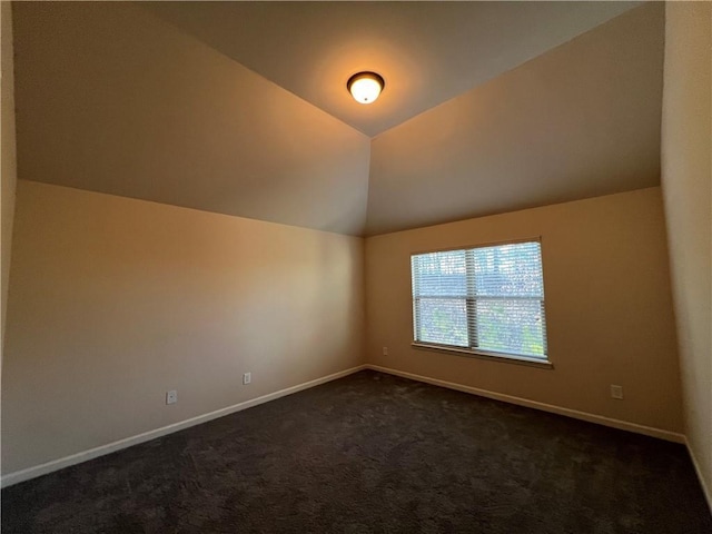 additional living space featuring dark carpet and vaulted ceiling