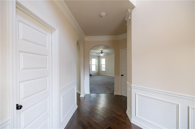 spare room featuring ornamental molding and dark colored carpet