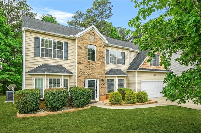 colonial inspired home with concrete driveway, roof with shingles, a front lawn, and an attached garage