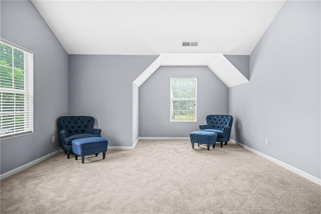 living area with visible vents, baseboards, lofted ceiling, and carpet floors