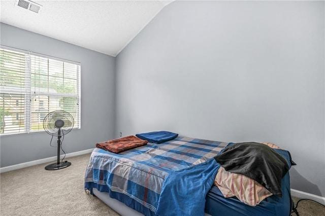bedroom with baseboards, visible vents, carpet floors, and vaulted ceiling
