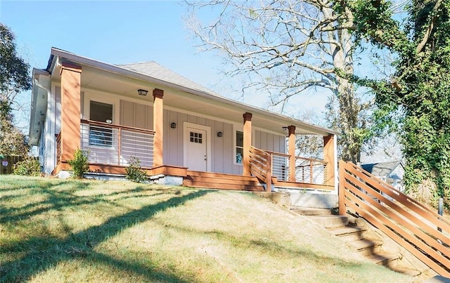 view of front of home featuring covered porch and a front lawn