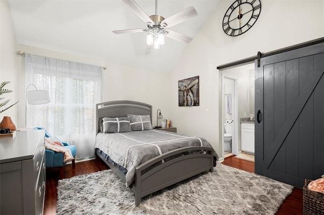 bedroom with connected bathroom, ceiling fan, a barn door, dark hardwood / wood-style flooring, and lofted ceiling