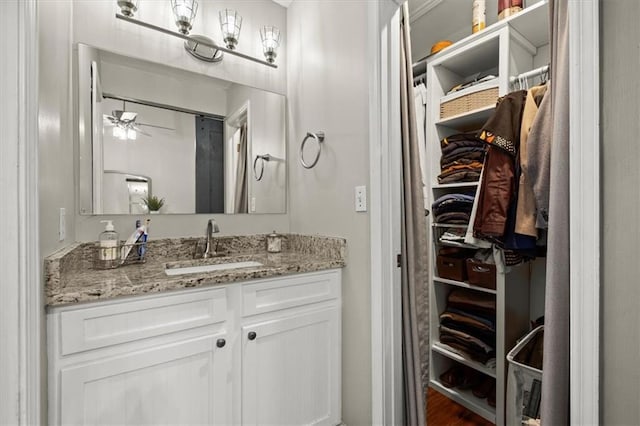 bathroom with hardwood / wood-style flooring, ceiling fan, and vanity