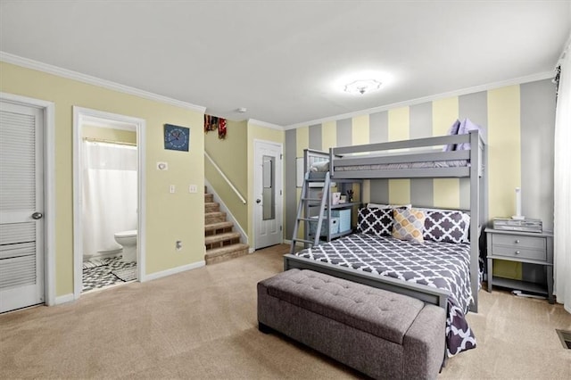 carpeted bedroom featuring ensuite bathroom and crown molding