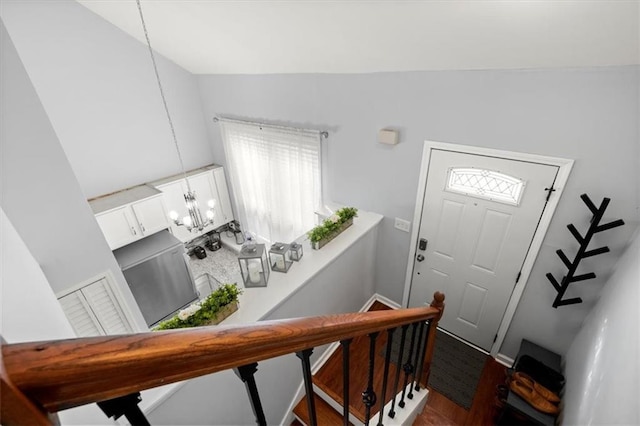 entryway with a chandelier, dark hardwood / wood-style floors, and lofted ceiling