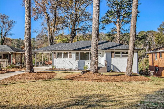 ranch-style house featuring a carport and a front lawn