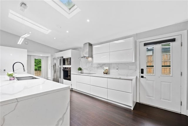 2123 Drew Valley Rd NE, Brookhaven, GA 30319 - kitchen featuring wall chimney exhaust hood, a sink, black appliances, modern cabinets, and a skylight