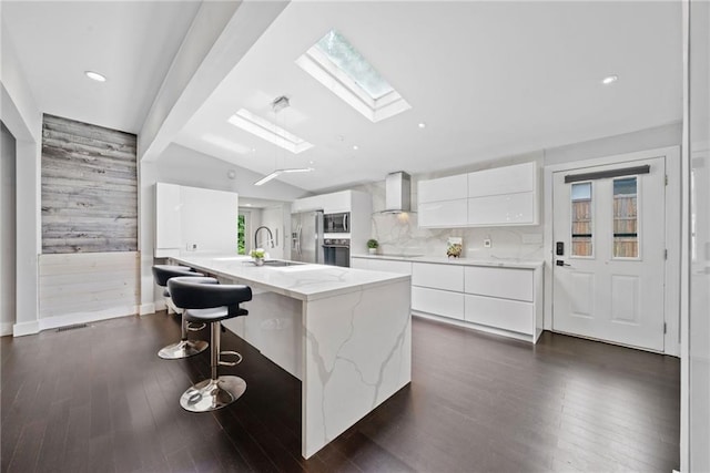 2123 Drew Valley Rd NE, Brookhaven, GA 30319 - kitchen featuring wall chimney exhaust hood, modern cabinets, a skylight, a sink, and white cabinets