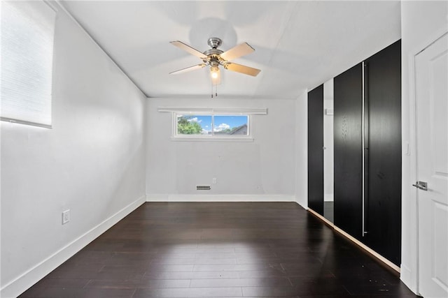 2123 Drew Valley Rd NE, Brookhaven, GA 30319 - unfurnished bedroom with baseboards, wood finished floors, and ceiling fan