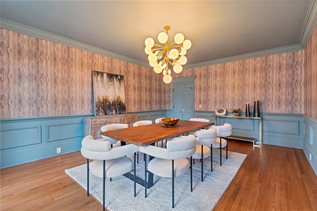 dining area with light hardwood / wood-style flooring, crown molding, and a notable chandelier