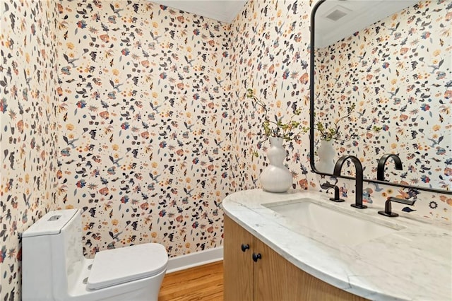 bathroom featuring ornamental molding, hardwood / wood-style flooring, toilet, and vanity