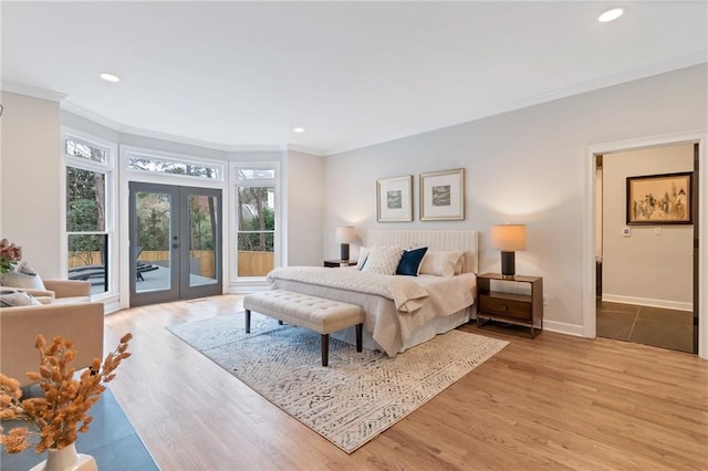 bedroom featuring ornamental molding, light hardwood / wood-style flooring, access to outside, and french doors