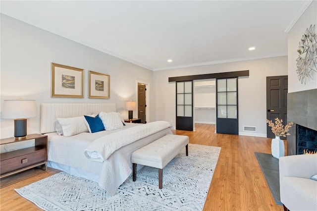 bedroom with ornamental molding and light wood-type flooring