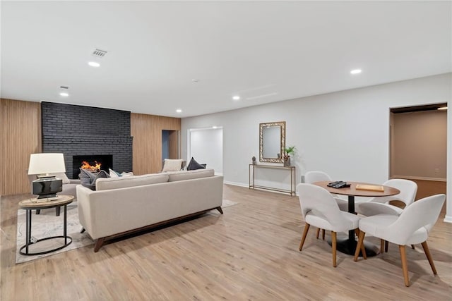 living room with light wood-type flooring and a fireplace