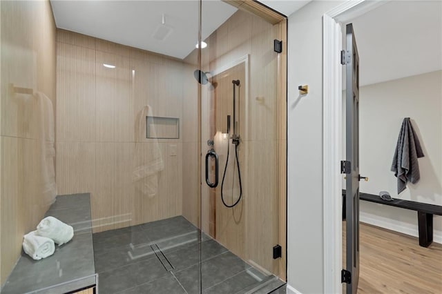 bathroom with hardwood / wood-style floors and an enclosed shower