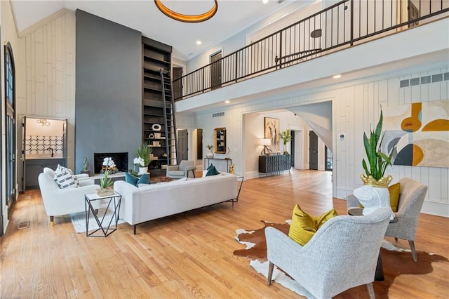 living room featuring light wood-type flooring and a towering ceiling