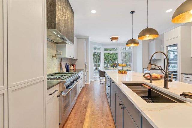 kitchen featuring light stone countertops, white cabinets, decorative light fixtures, decorative backsplash, and sink