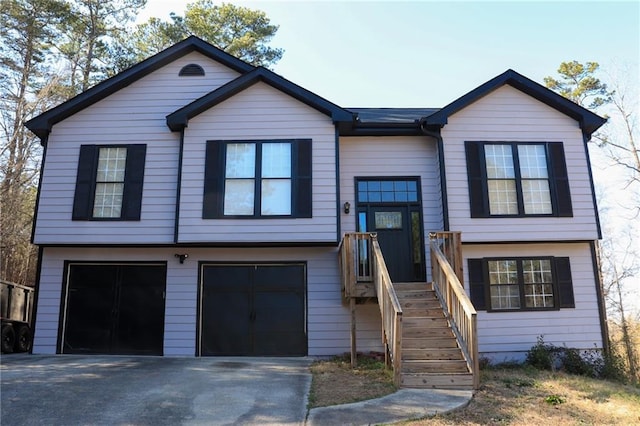 raised ranch featuring a garage and driveway