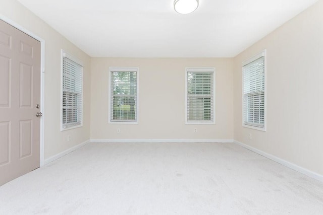 empty room featuring light colored carpet and a healthy amount of sunlight