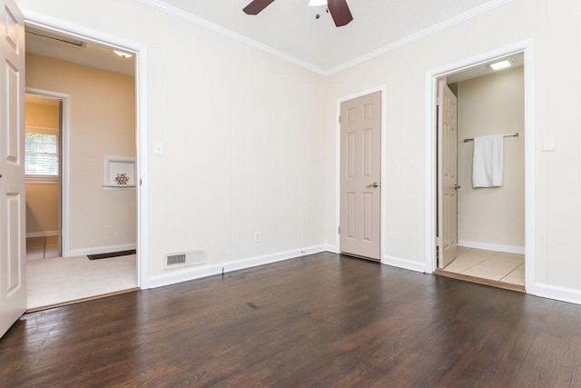 unfurnished bedroom with dark wood-type flooring, ceiling fan, ensuite bath, and crown molding