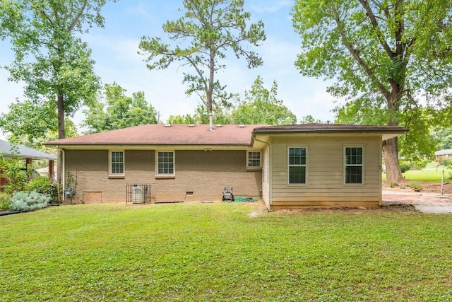 rear view of property featuring a lawn