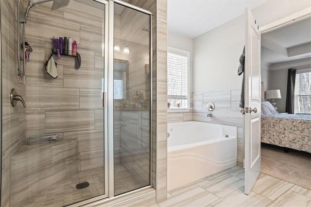 bathroom featuring independent shower and bath, a healthy amount of sunlight, and tile walls