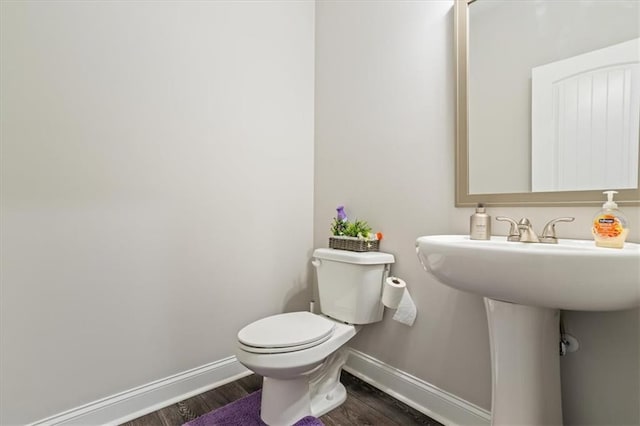 bathroom with hardwood / wood-style floors and toilet