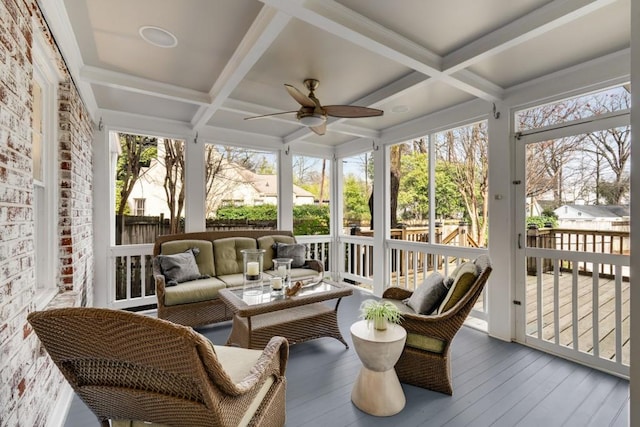 sunroom with beamed ceiling, coffered ceiling, a healthy amount of sunlight, and ceiling fan