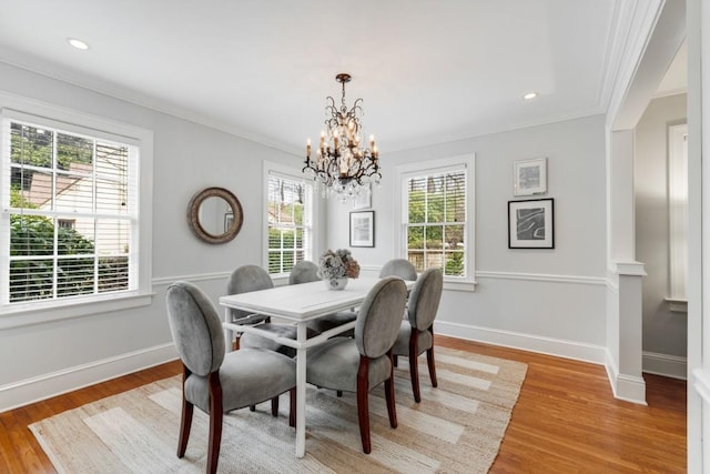 dining area with light wood-type flooring, baseboards, a healthy amount of sunlight, and ornamental molding