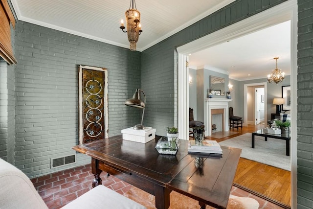 office area with visible vents, a fireplace, brick wall, and ornamental molding