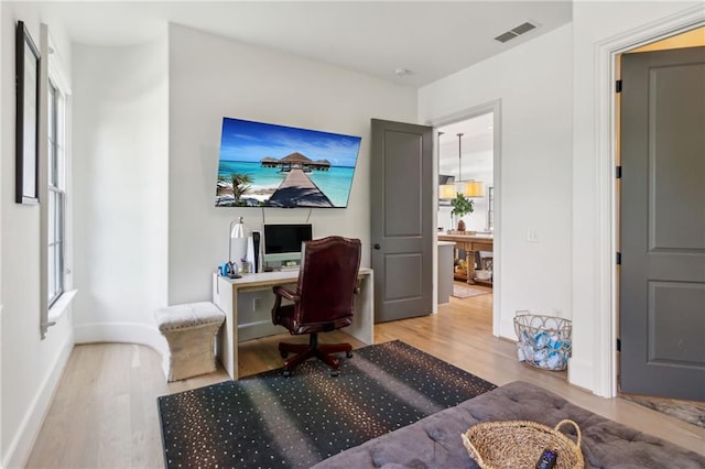 home office with baseboards, wood finished floors, and visible vents