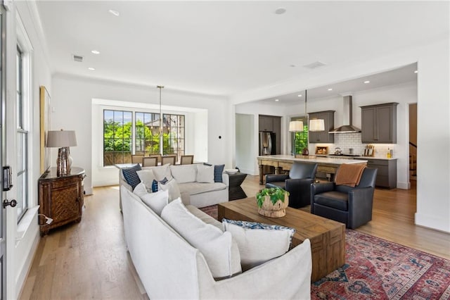 living room with recessed lighting, visible vents, and light wood finished floors