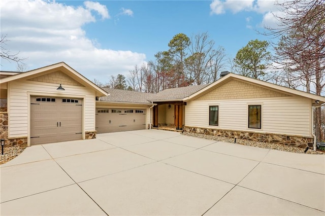 ranch-style house featuring a garage, driveway, and stone siding