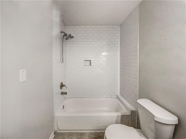 bathroom featuring tiled shower / bath and toilet