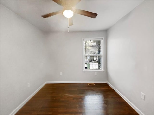 empty room with ceiling fan and dark hardwood / wood-style flooring