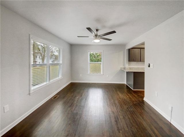 unfurnished living room featuring ceiling fan and dark wood-type flooring