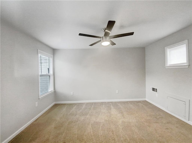 carpeted spare room featuring ceiling fan