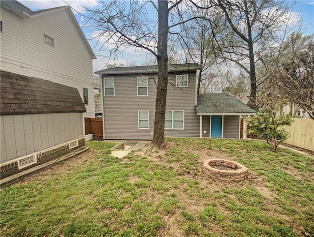 rear view of property with a yard, an outbuilding, and an outdoor fire pit